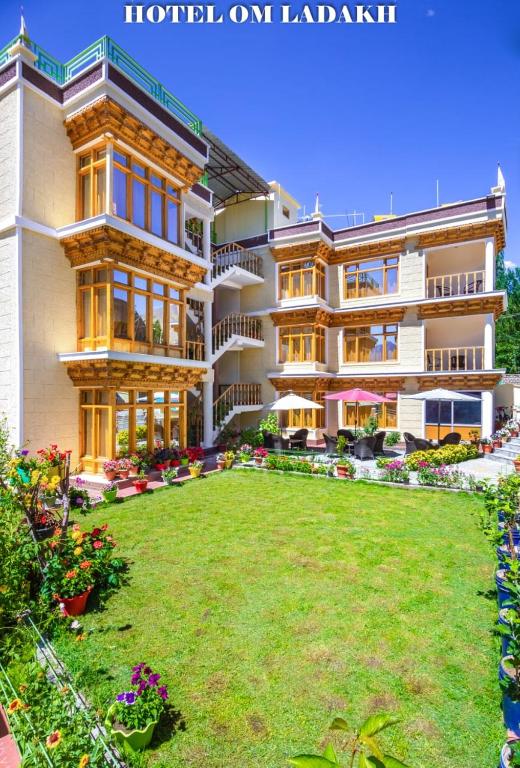 a large building with a lawn in front of it at Hotel Om Ladakh in Leh