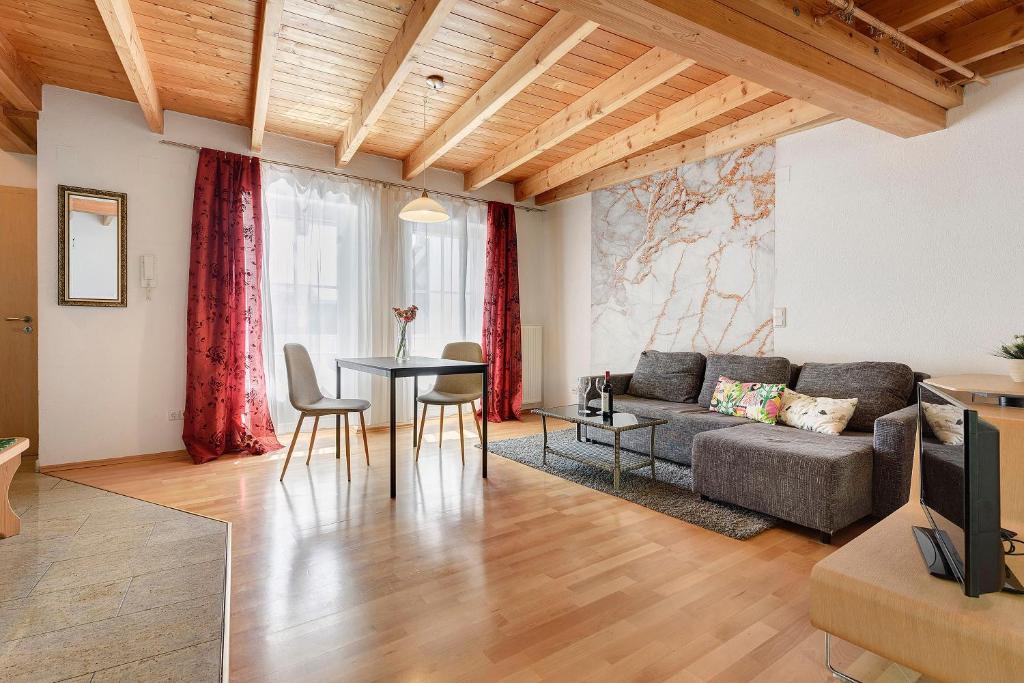 a living room with a couch and a table at Charming Lakenear Apartment in Sipplingen