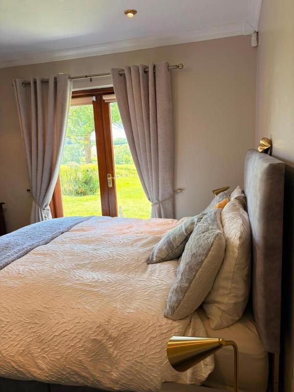 a bedroom with a bed with pillows and a window at 2 Bedroom Apartment - Free Parking & Garden in Kilmessan