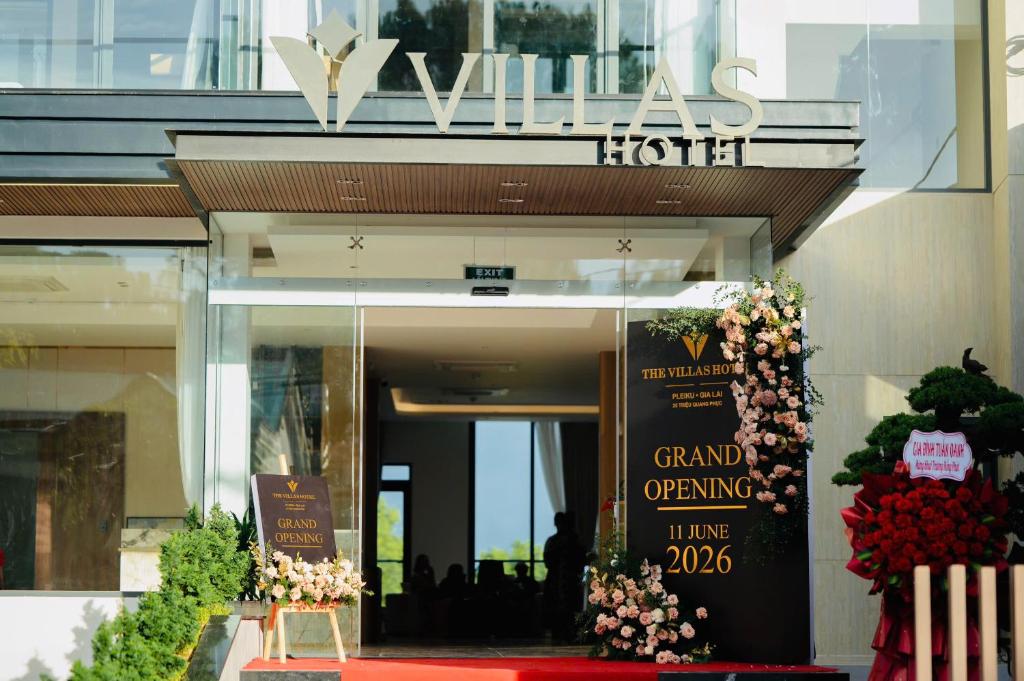 a building with a grand opening sign and flowers at The Villas Hotel in Pleiku