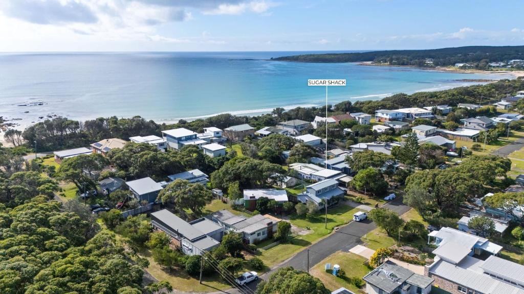 an aerial view of a town with houses and the ocean at Sugar Shack Currarong in Currarong