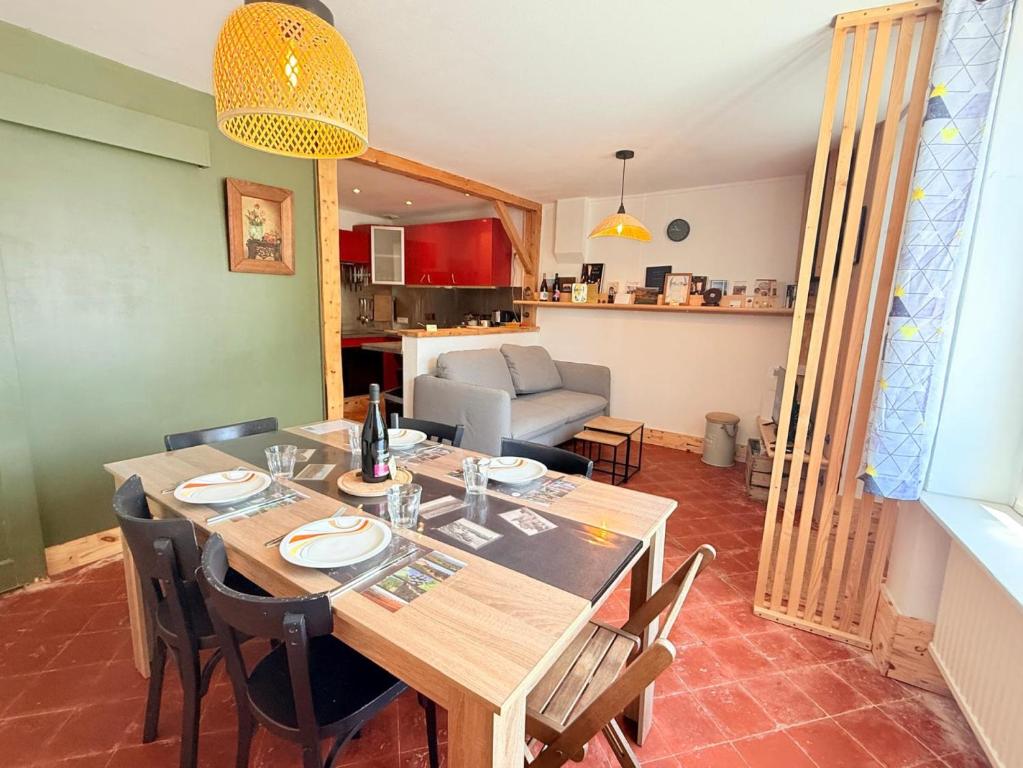 a dining room with a wooden table and chairs at La maison du père Bellessort in Régnié