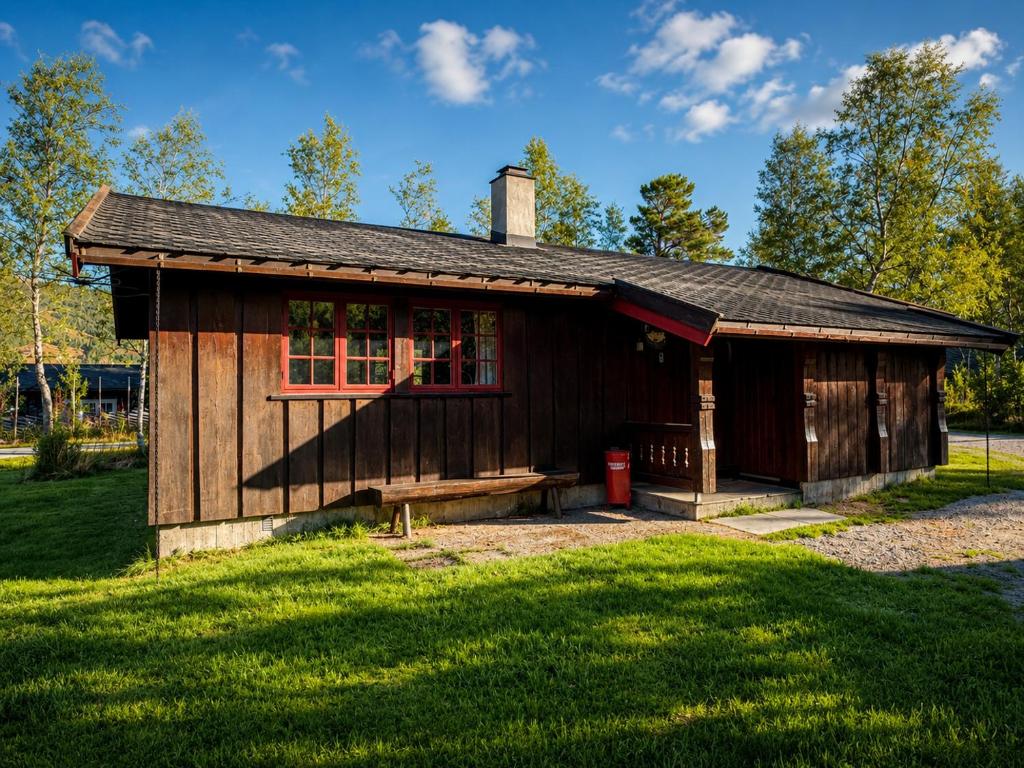 a small wooden building with a window on a field at Briskebu, cosy cabin by ski slopes in Geilo