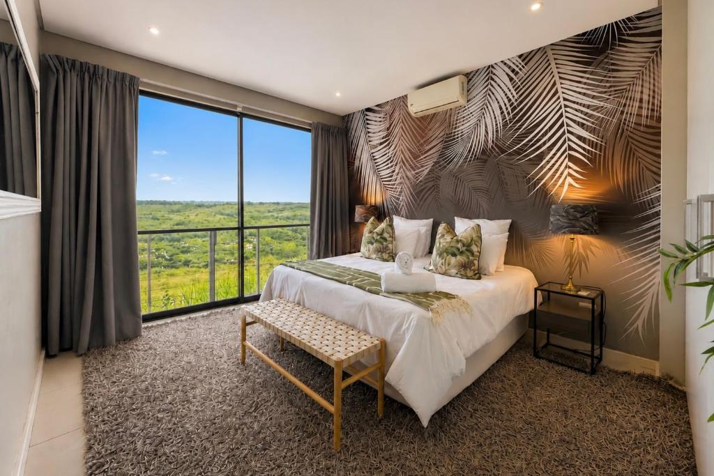 a bedroom with a large bed and a large window at Ballito Zimbali Wedge in Ballito