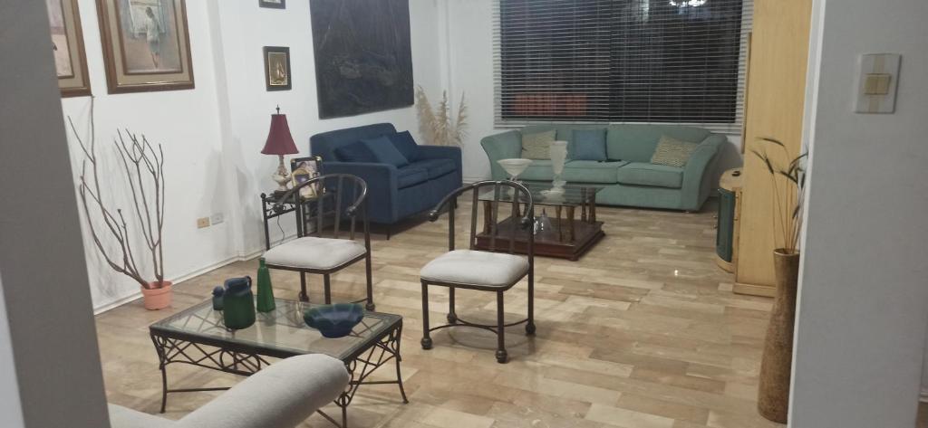 ein Wohnzimmer mit Sofa, Stühlen und Tischen in der Unterkunft Casa Ivana in Guayaquil