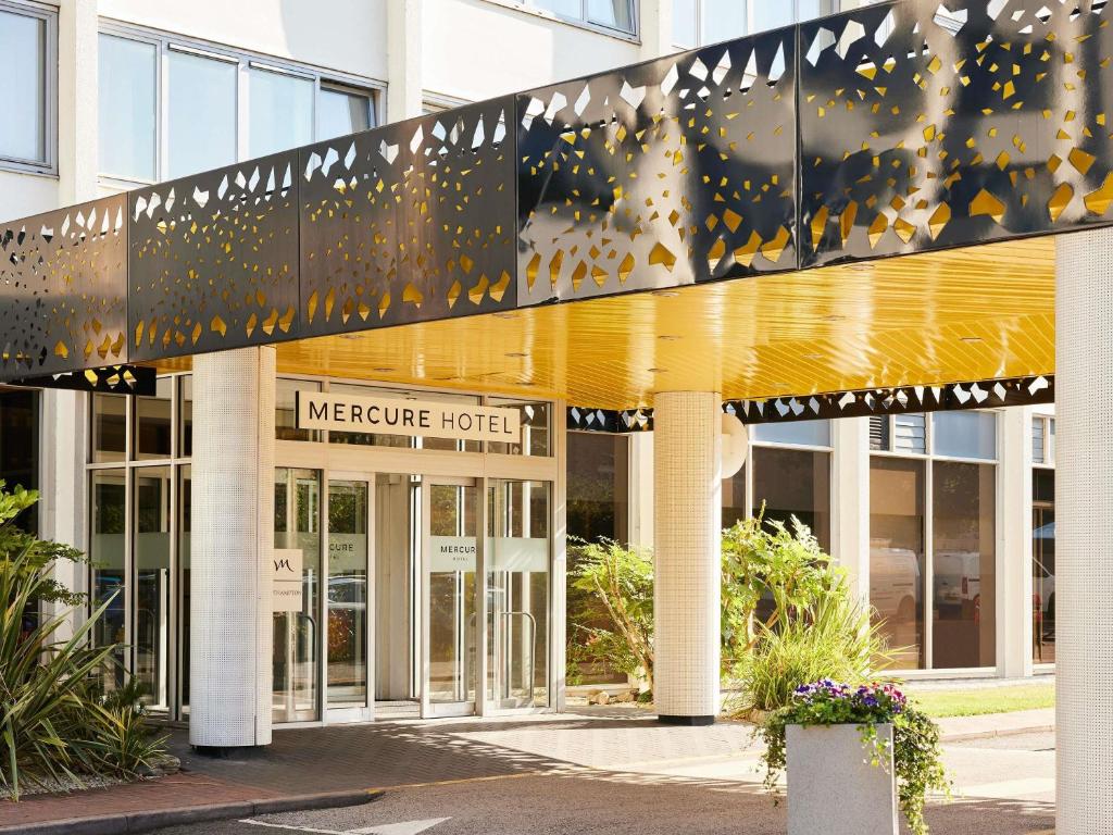 a large building with a yellow and white building at Mercure Northampton in Northampton