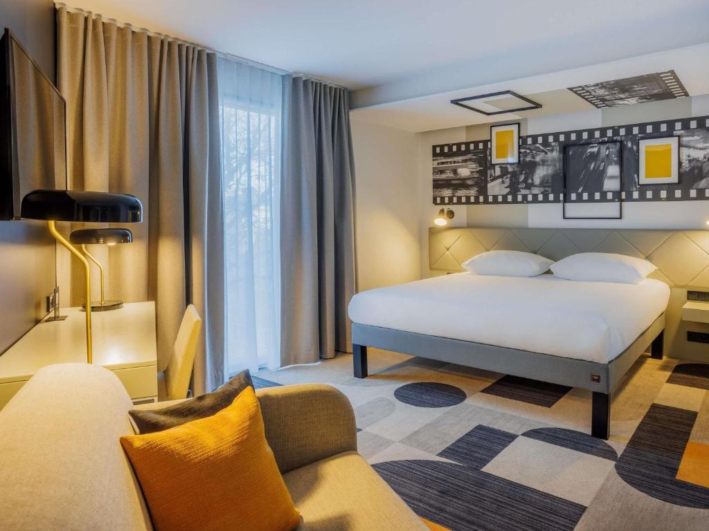 a hotel room with a bed and a couch at ibis Styles Tallinn in Tallinn