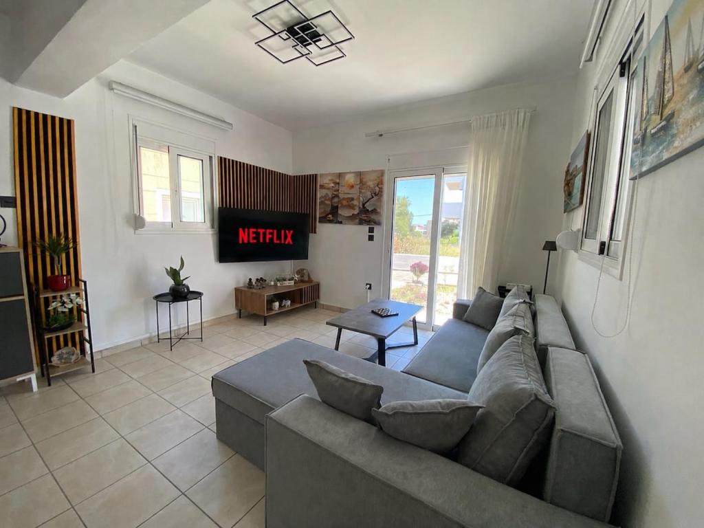 a living room with a couch and a tv at Gennadi Escape House in Gennadi