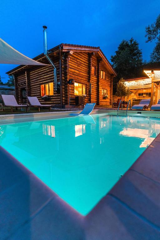 a swimming pool in front of a log cabin at Holzhaus in Sadu