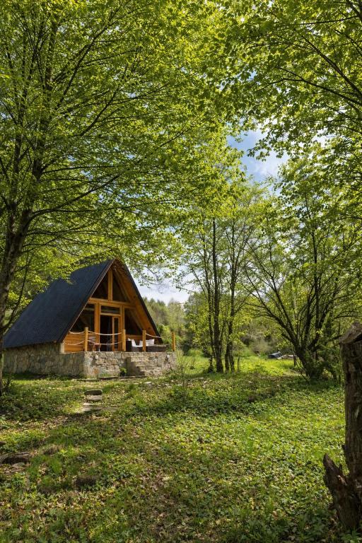 a cabin in the middle of a field with trees at Holiday Home Veruša in Podgorica