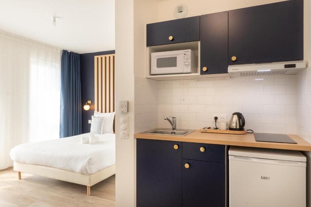 a small kitchen with a bed and a microwave at Ibis Styles Paris Pont d'Ivry in Ivry-sur-Seine