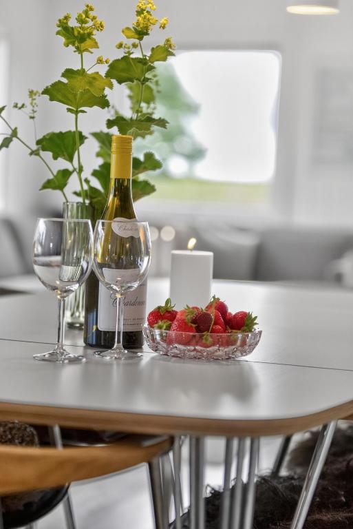 a table with a bottle of wine and a candle and strawberries at Family Holiday Home with Jacuzzi and Fireplace in Hejls