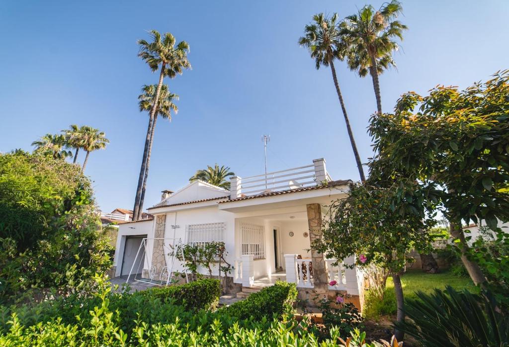 a white house with palm trees in front of it at Villa Marie in Benicarló