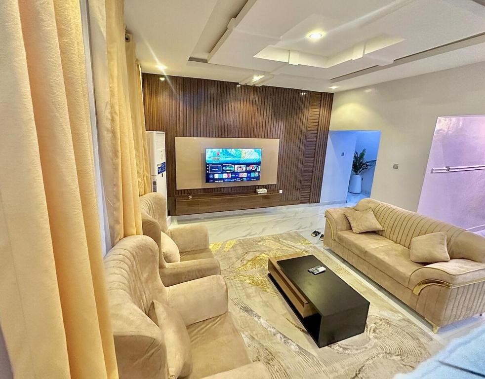 a living room with couches and a flat screen tv at Serene 5 Bedroom Duplex With Exclusive Compound in Iseri