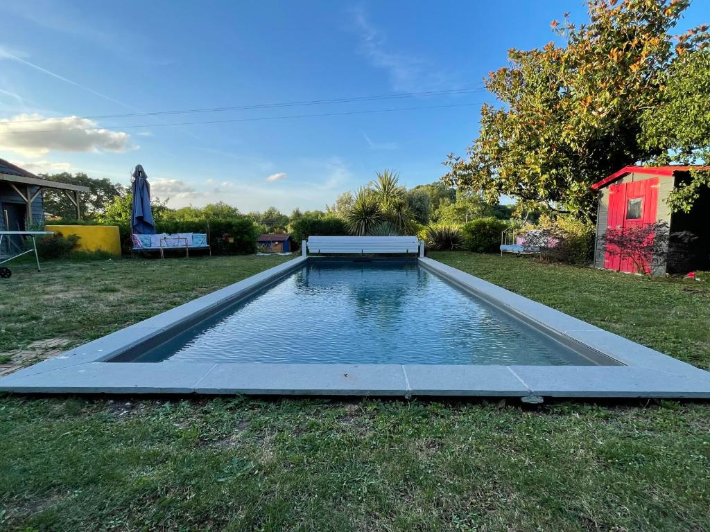 a swimming pool in the middle of a yard at La chambre des jardins d'Ispahan in Prignac-et-Marcamps