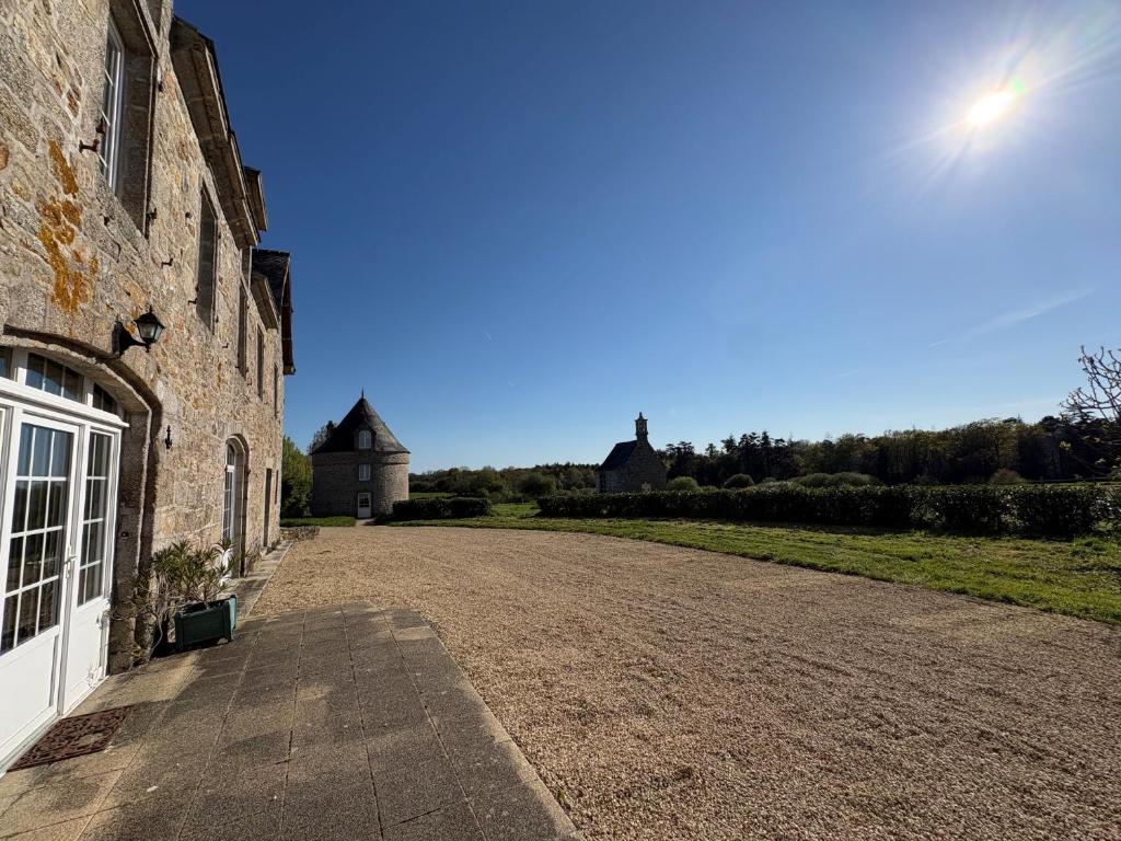 a dirt road next to a stone building with a house at Longère près des plages, 11 pers 5 chambres! in Trégunc