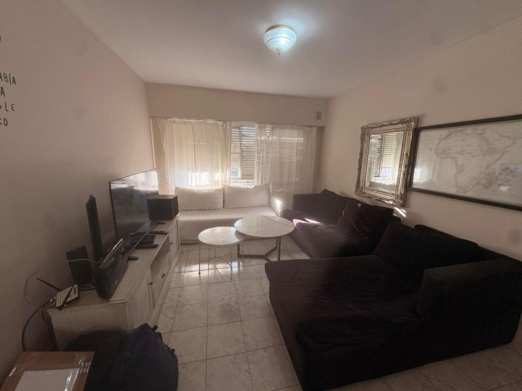 a living room with a couch and a tv at Osiris Apart in Comodoro Rivadavia