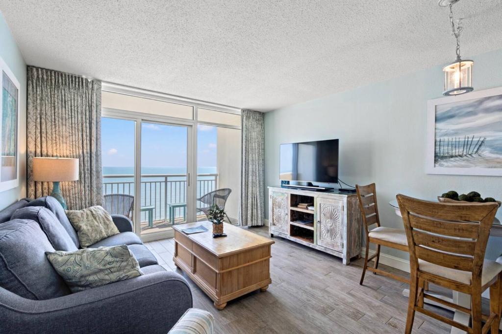a living room with a couch and a television at Bay Watch Resort 1735 - Direct Oceanfront Balcony with Pools and Lazy River in Myrtle Beach