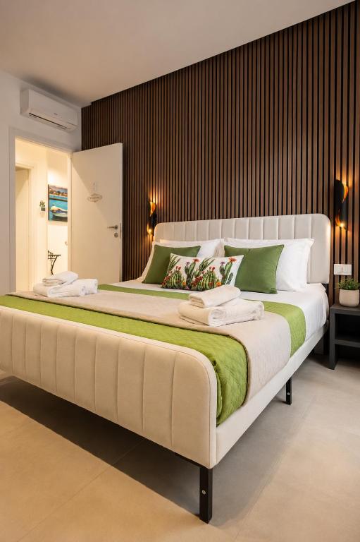a large bed with green and white pillows on it at Sicily Luxury Rooms in Palermo