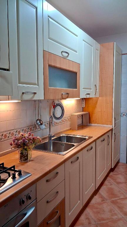 a kitchen with white cabinets and a sink at NUOVO Alloggio Giardino di Rosy tra Roma EUR e il Mare di Ostia in Vitinia