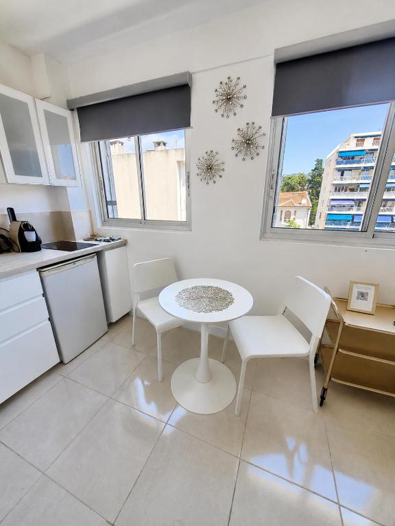 a kitchen with a table and chairs in a room at Cannes Centre Studio Lumineux et Chic, à 9 Min à Pied du Palais des Festivals et des Plages, Clim in Cannes