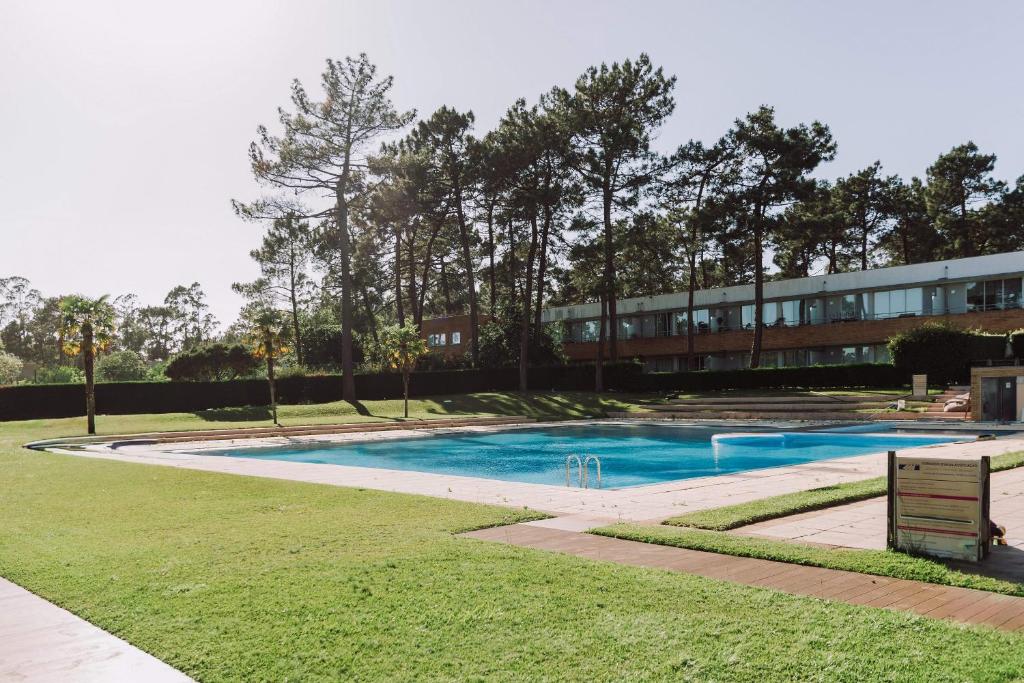 a swimming pool in front of a building at Casa da Barca Pool & Golf by TonsdeVerde in Esposende