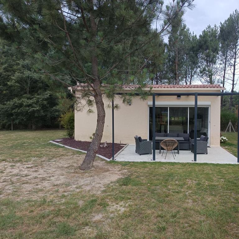 a house with a tree in the yard at Appartement Marilou in Pompiey