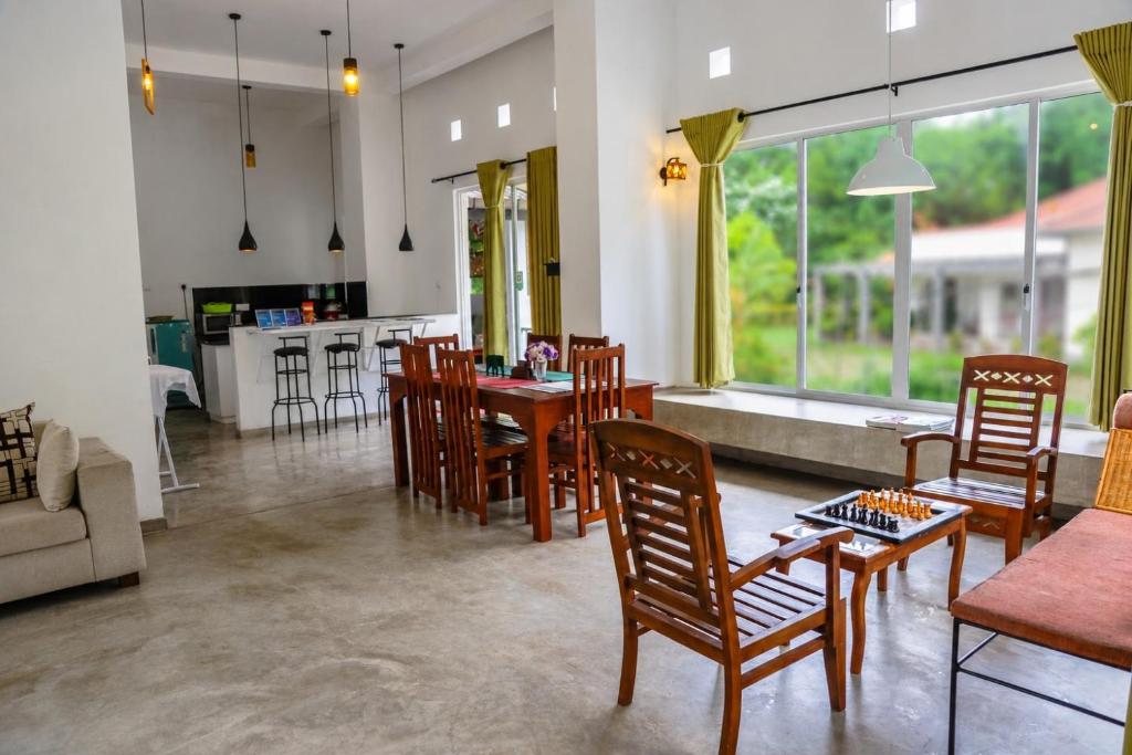 a living room with a table and chairs and a kitchen at Everdew Kandy in Kandy