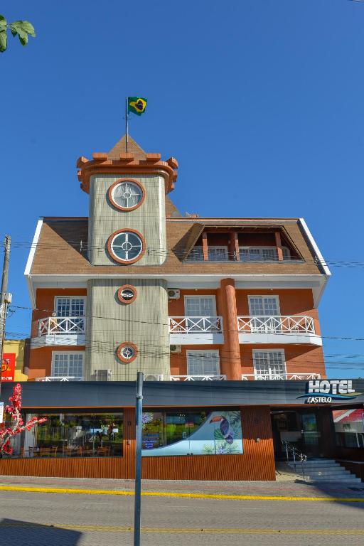 a building with a clock tower on top of it at Hotel Castelo in Gravatal