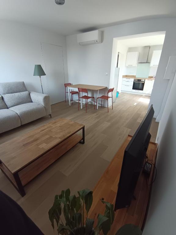 a living room with a couch and a table at Appartement Neuf avec Balcon in Hendaye