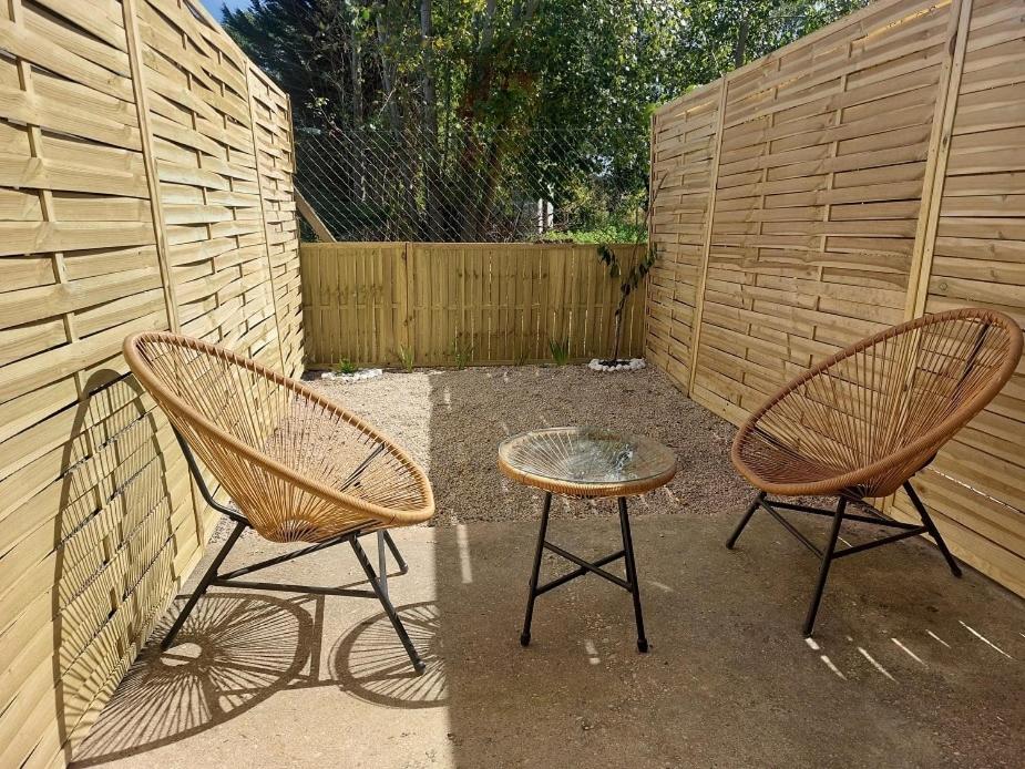 two chairs and a table in front of a fence at Pavillon - T2 Duplex avec Terrasse et Parking in Montagnat