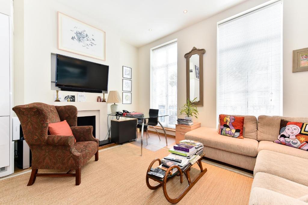 a living room with a couch and a tv at Elegant 3 bed apt with rooftop terrace in Pimlico in London