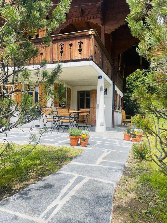 a building with a porch with potted plants on it at Chalet Royal in Les Diablerets