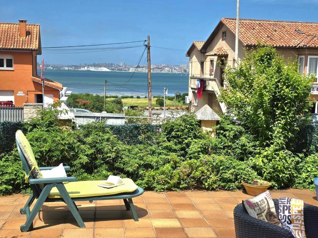 a patio with a table and a chair and the ocean at Apartamento Ora al Mare - 32002 in Pedreña