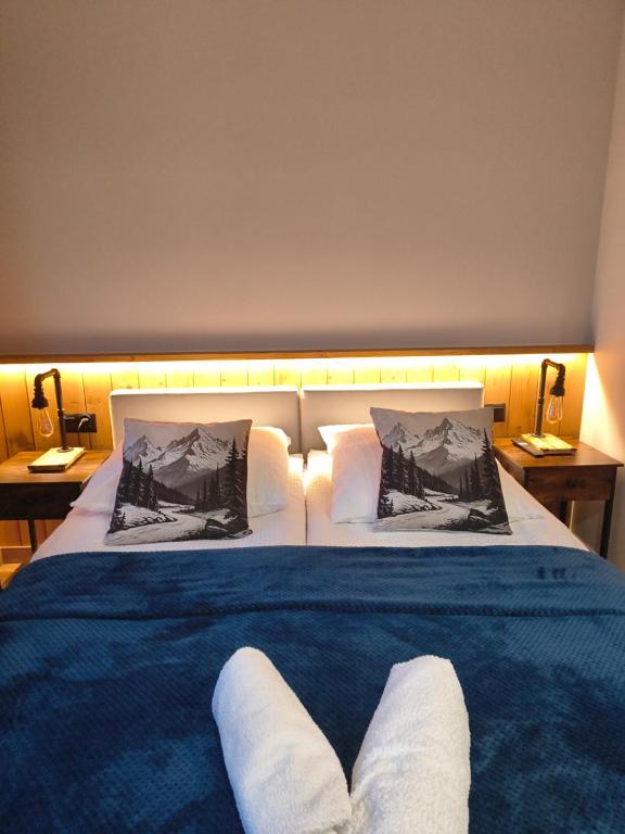 a bedroom with a large bed with two white pillows at Sądelska Chałpa in Murzasichle
