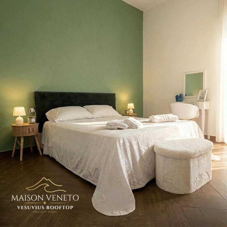 a bedroom with a large bed with a white comforter at Maison Veneto Vesuvius Rooftop in Torre Annunziata