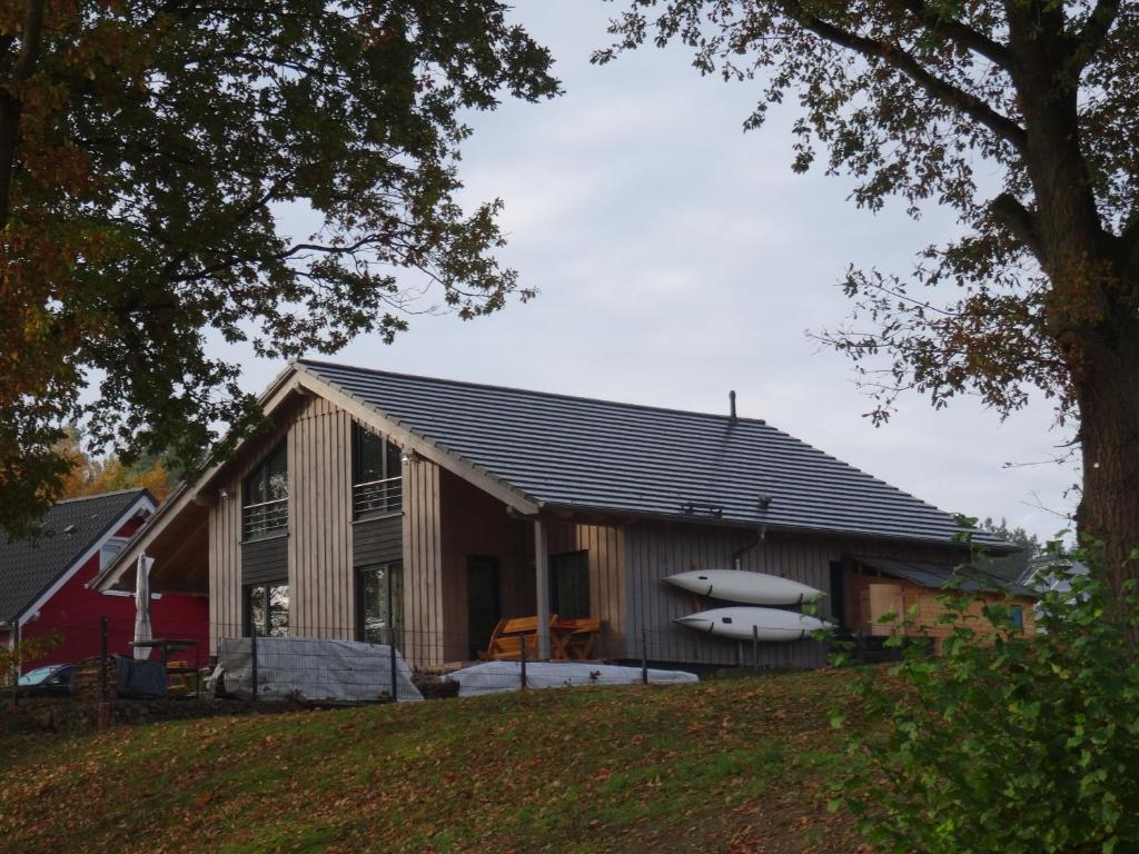 a house with a boat on the side of it at Ferienhaus Seeblick in Rheinsberg