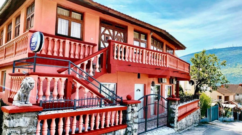 a red house with a statue in front of it at Villa Đuričić 200m od mora in Đenovići