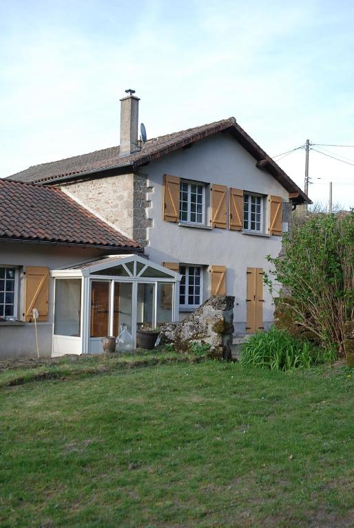 a large white house with a yard in front of it at Etape motards chez Fred et Flo in Compreignac