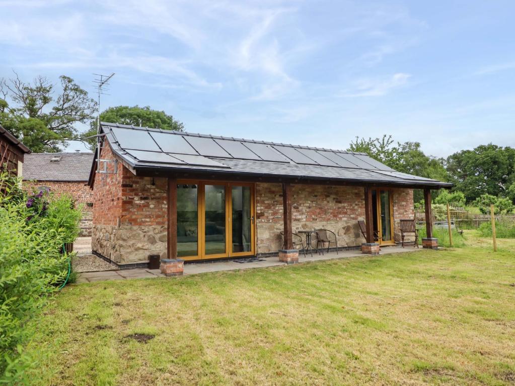 a brick house with a solar roof on a yard at Henlle Home Farm in Oswestry