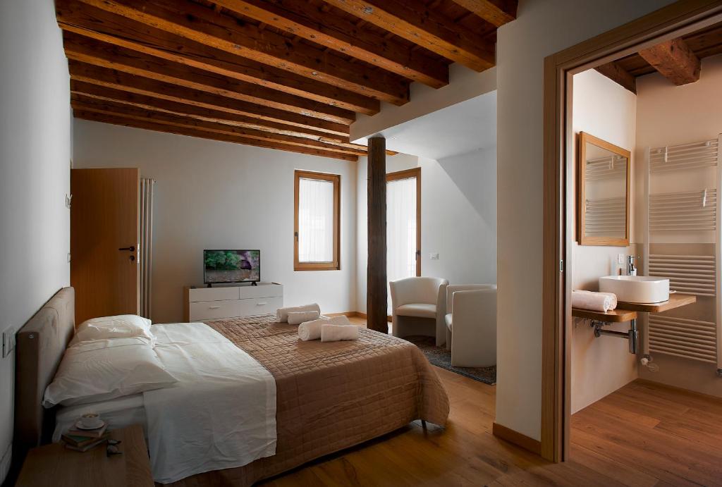 ein Schlafzimmer mit einem großen Bett und ein Badezimmer in der Unterkunft Rum Oliero in Valbrenta 