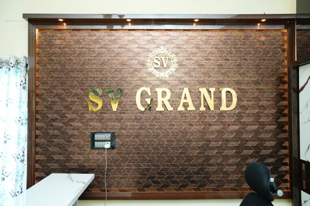 a sign that says synergy grand on a wall at SV Grand in Kākināda