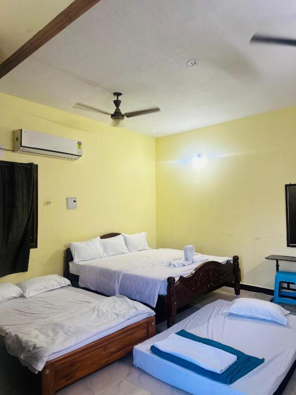 a room with two beds and a tv in it at The ARCS in Madurai
