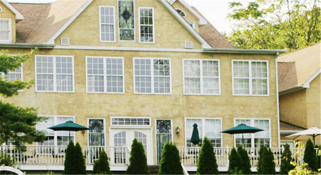 a house with white windows and umbrellas in front of it at Elk Forge Bed and Breakfast in Elkton