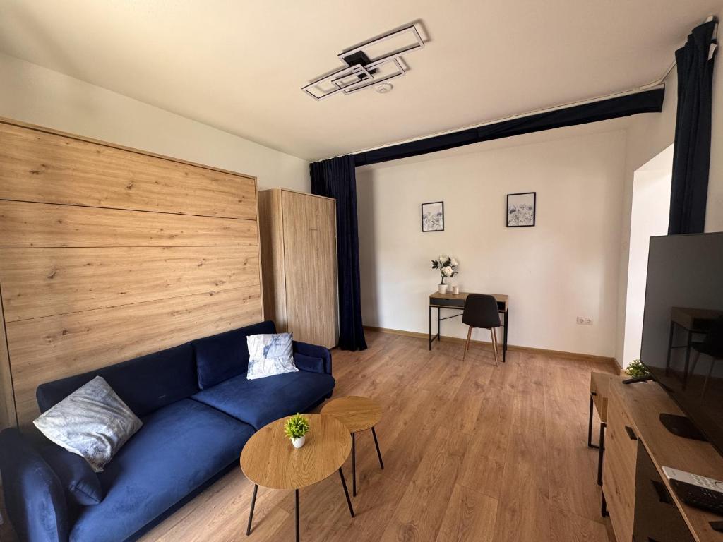 a living room with a blue couch and a table at Tisza-tó Porta in Tiszafüred