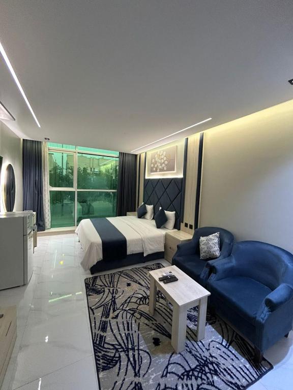 a hotel room with a bed and a blue couch at شقق فاخرة in Riyadh