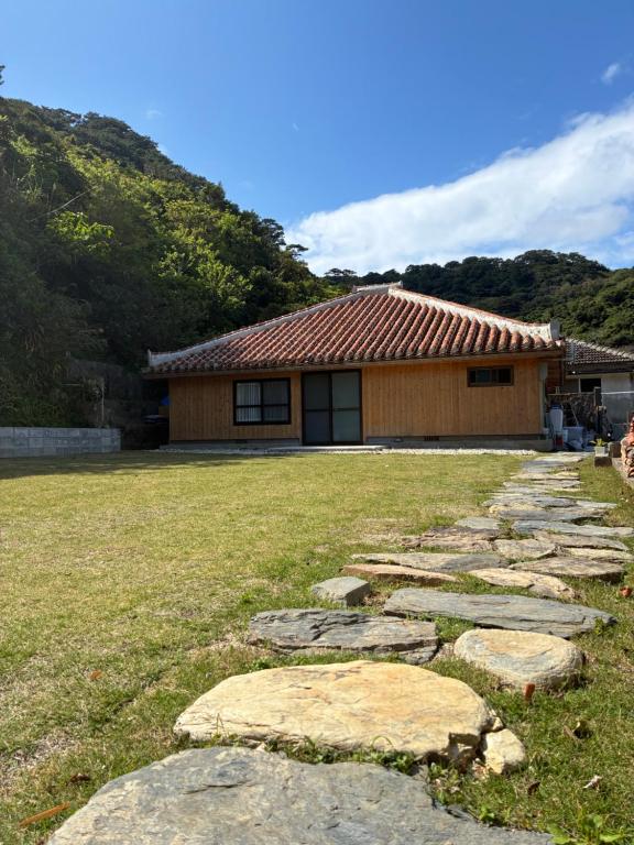a stone path in front of a house at 赤瓦のお宿みあげむい in Kunigami