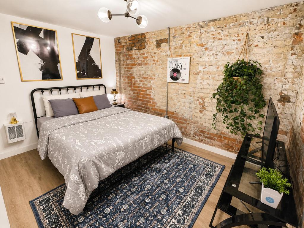 a bedroom with a bed and a brick wall at Downtown Detroit Hidden Gem Walk to Venues & DMC in Detroit