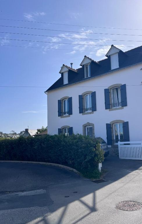 a large white building with black shutters on it at Ker Lucie in Crozon