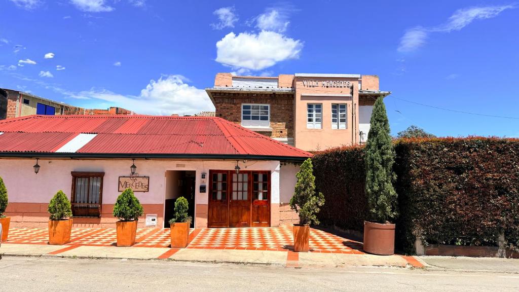 a building with a red roof on a street at Hotel Boutique Villa Mercedes in Sopó